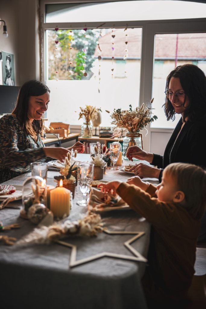 Repas en famille autour d'une table joliment décorée autour des fleurs séchées